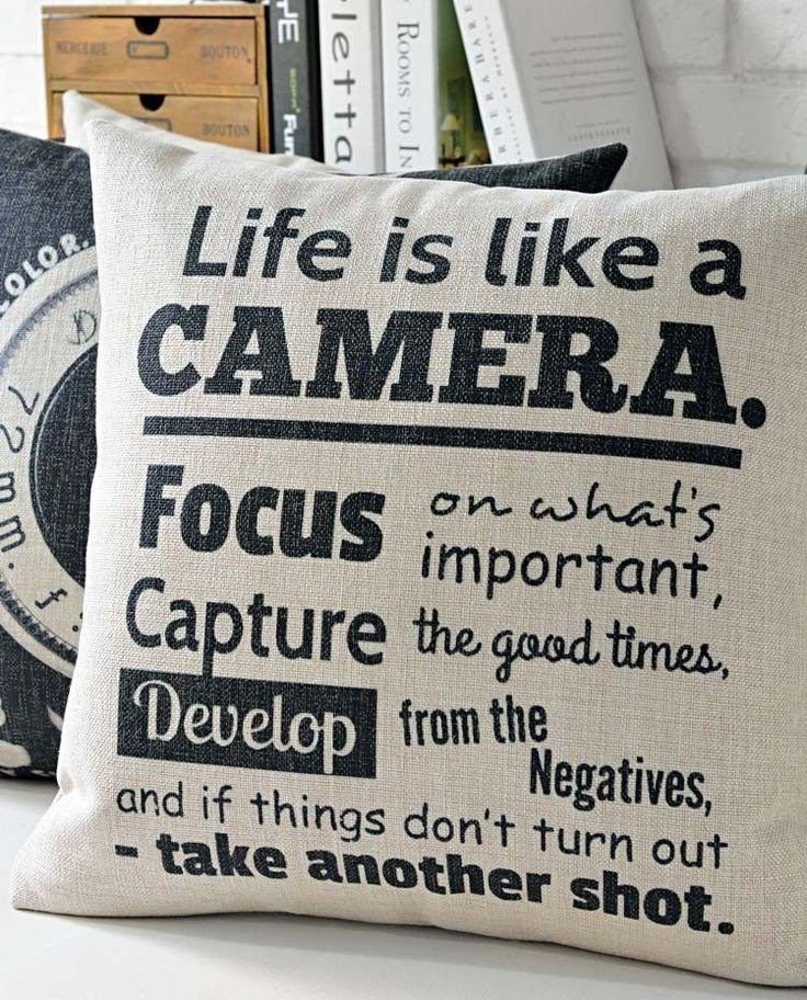 two pillows sitting on top of a white table next to books and other things in front of them