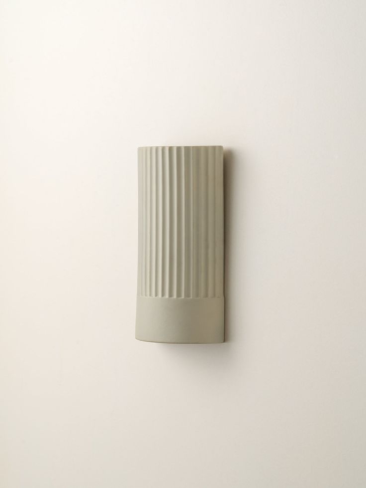 a white wall mounted object on the side of a wall with a light bulb attached to it