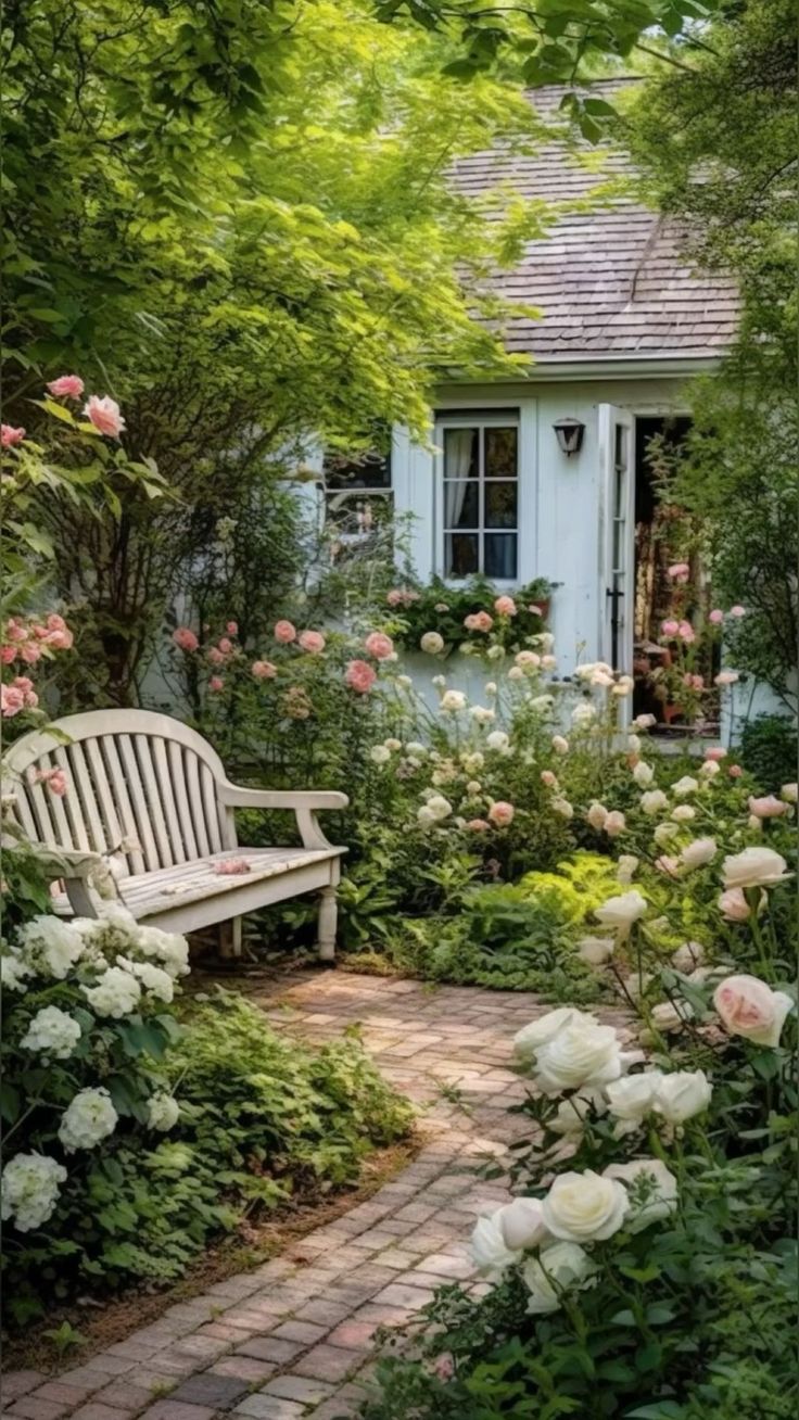 a white bench sitting in the middle of a garden next to some trees and flowers