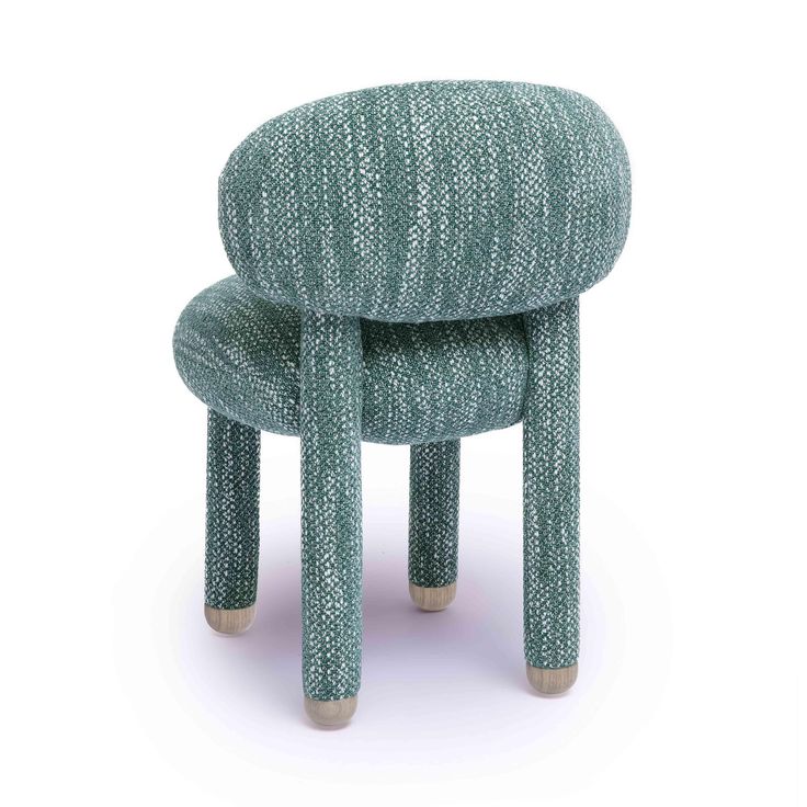 a small stool made out of knitted fabric and wooden legs, sitting on a white surface