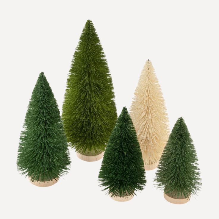 four small trees are shown in three different colors and sizes, one is white the other is green