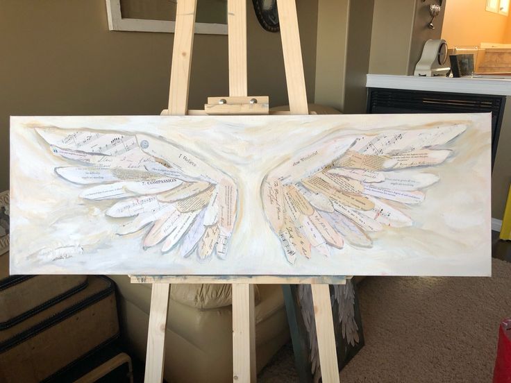 an easel is holding up a painting with wings on it