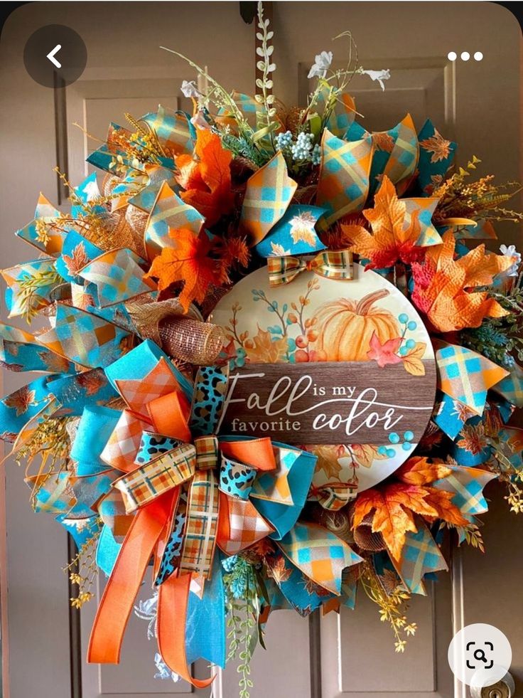 a fall wreath with an orange and blue bow hanging from the front door that says, autumn is my favorite color