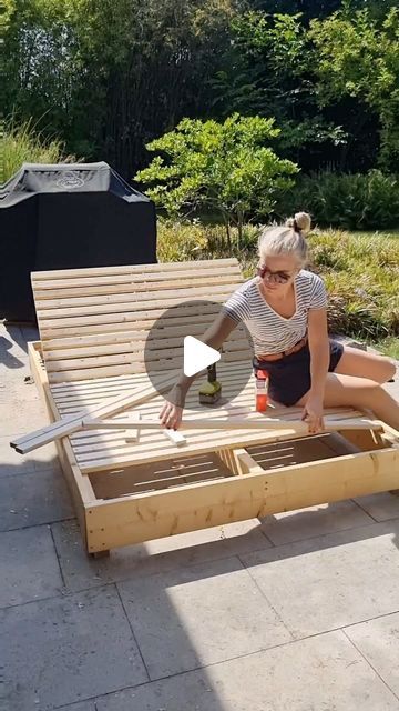 a woman sitting on top of a wooden bench