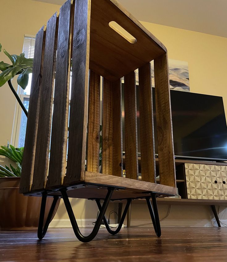 a wooden chair sitting on top of a hard wood floor next to a tv monitor