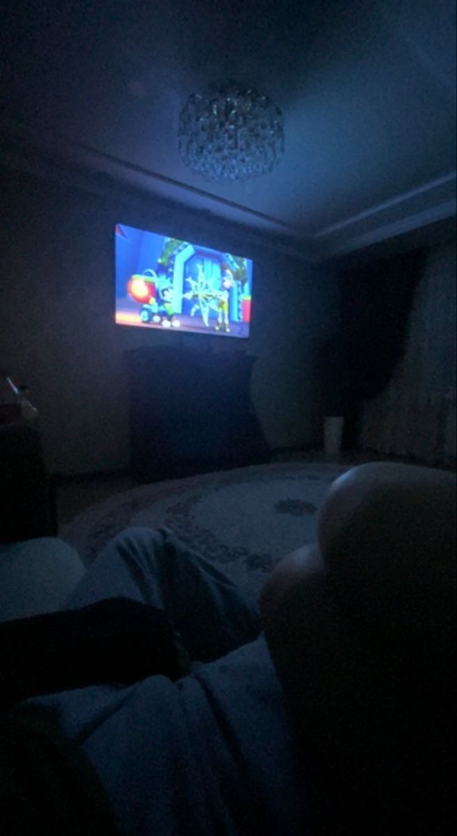 a person is watching television in the dark