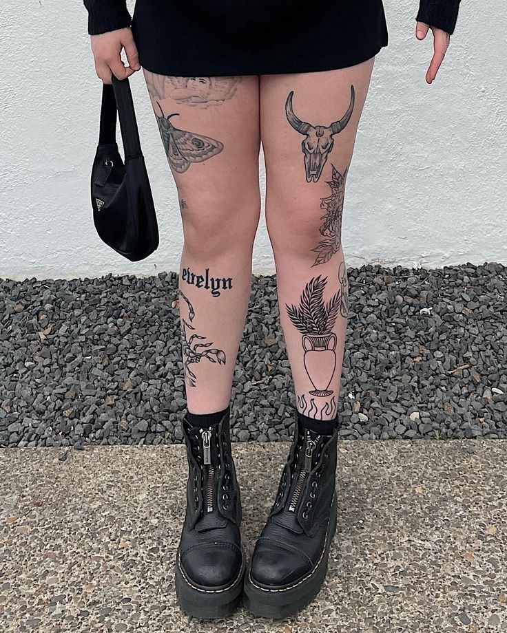 a woman with tattoos on her legs and leggings is holding a handbag