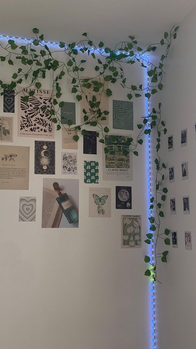 a white wall covered in lots of different types of pictures and plants growing on it