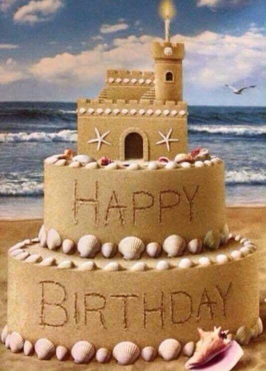 a sand castle on the beach that says happy birthday with shells and seashells around it