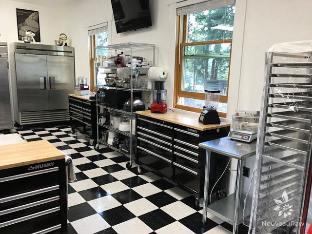 a kitchen with black and white checkered flooring and stainless steel appliances in it