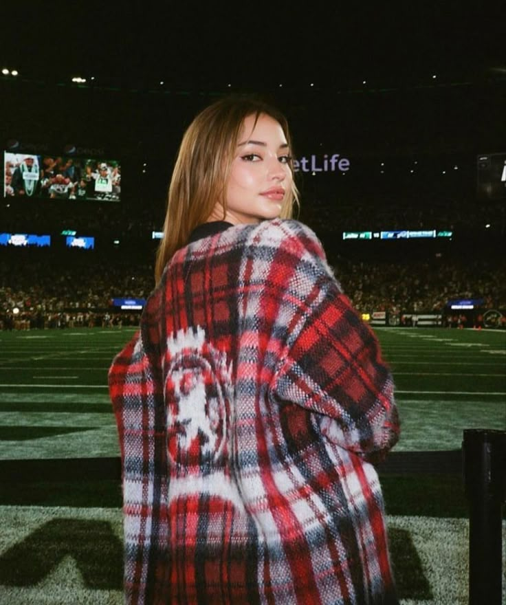 a woman wearing a red and black plaid coat