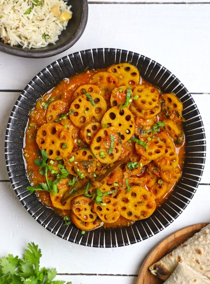 a plate with some food on top of it next to a bowl of rice and pita bread