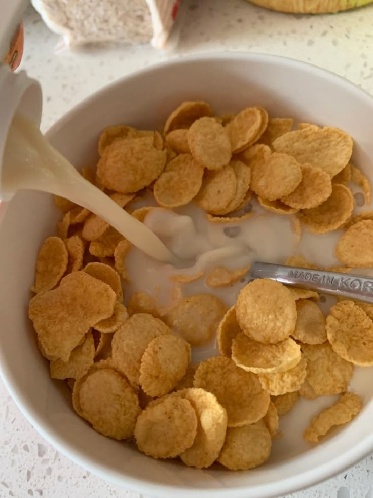 a bowl filled with cereal and milk being poured into it