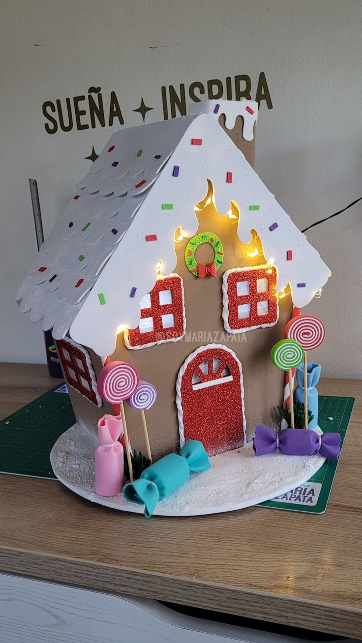 a gingerbread house with lights and decorations on the roof is shown in front of a wall