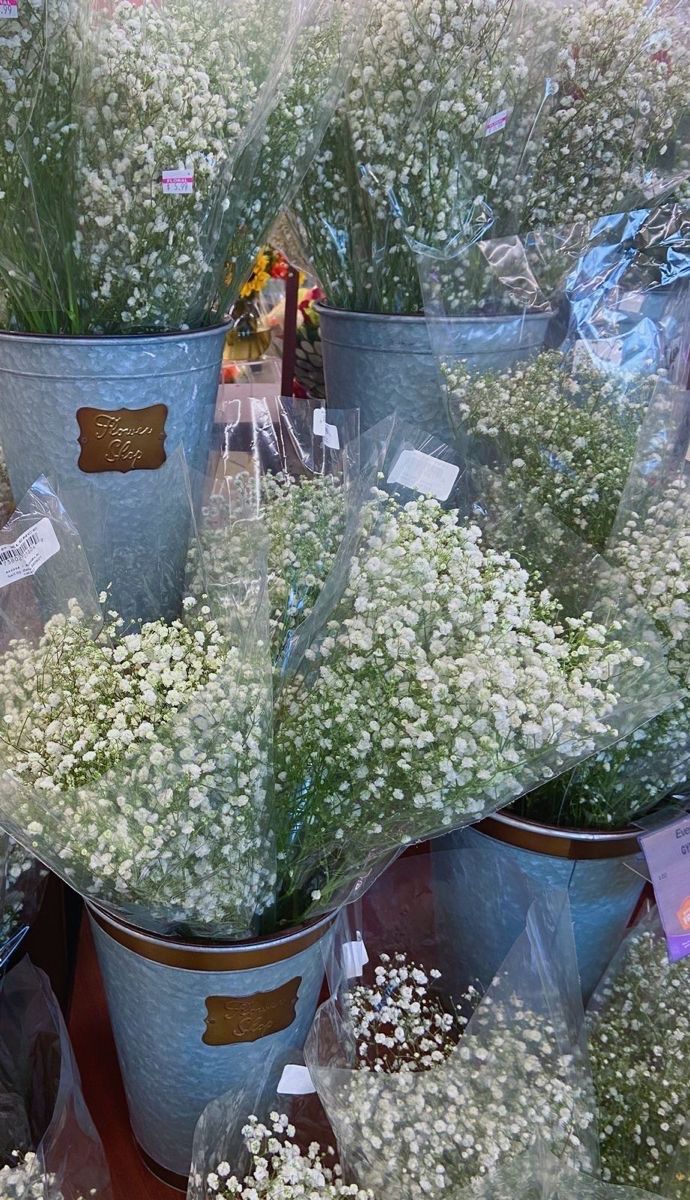 several buckets filled with baby's breath flowers sitting on top of a table