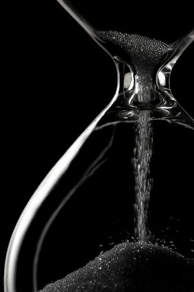 an hourglass with water pouring out of it and the words in arabic above it