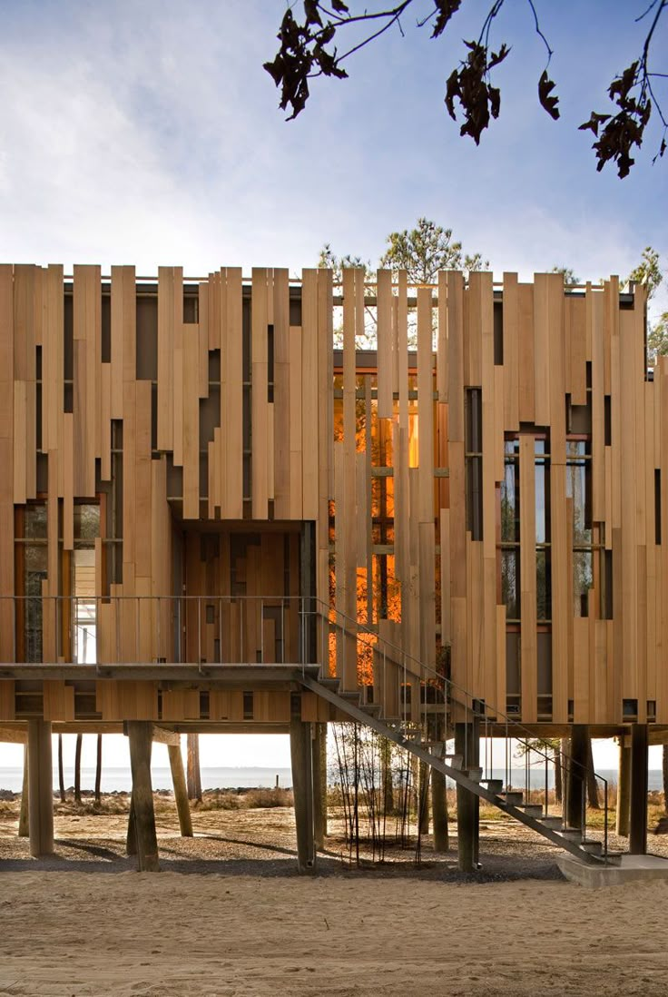 a building made out of wooden planks with stairs leading up to the top floor