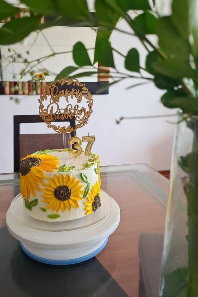 a cake with sunflowers on it sitting on a table