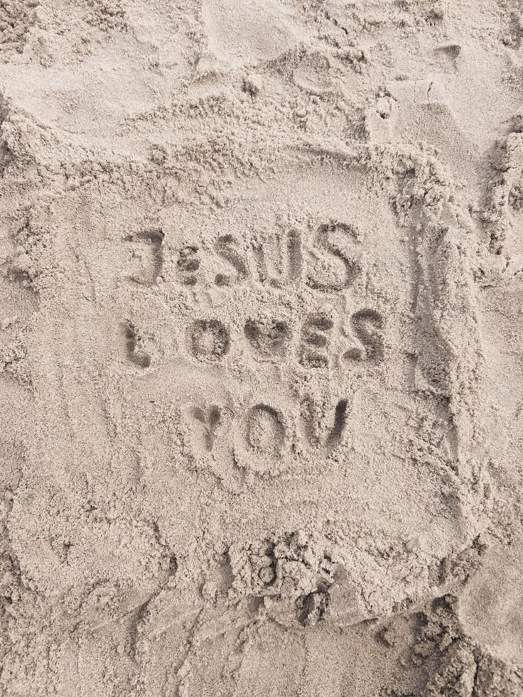 the words jesus loves you written in the sand