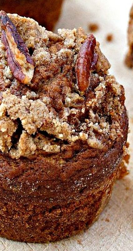 there is a muffin that has been topped with crumbs and pecans