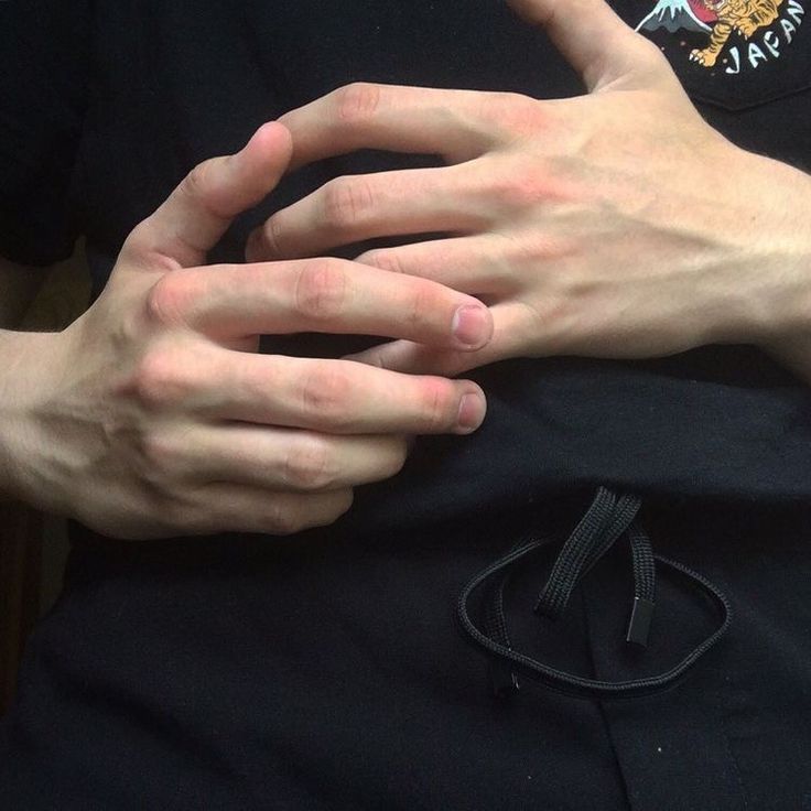 a person holding their hands together in the middle of his chest and wearing a black t - shirt