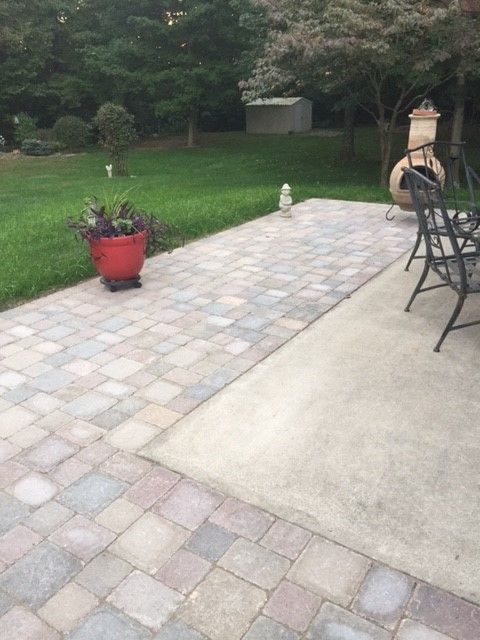 a patio with chairs and a potted planter on the ground in front of it