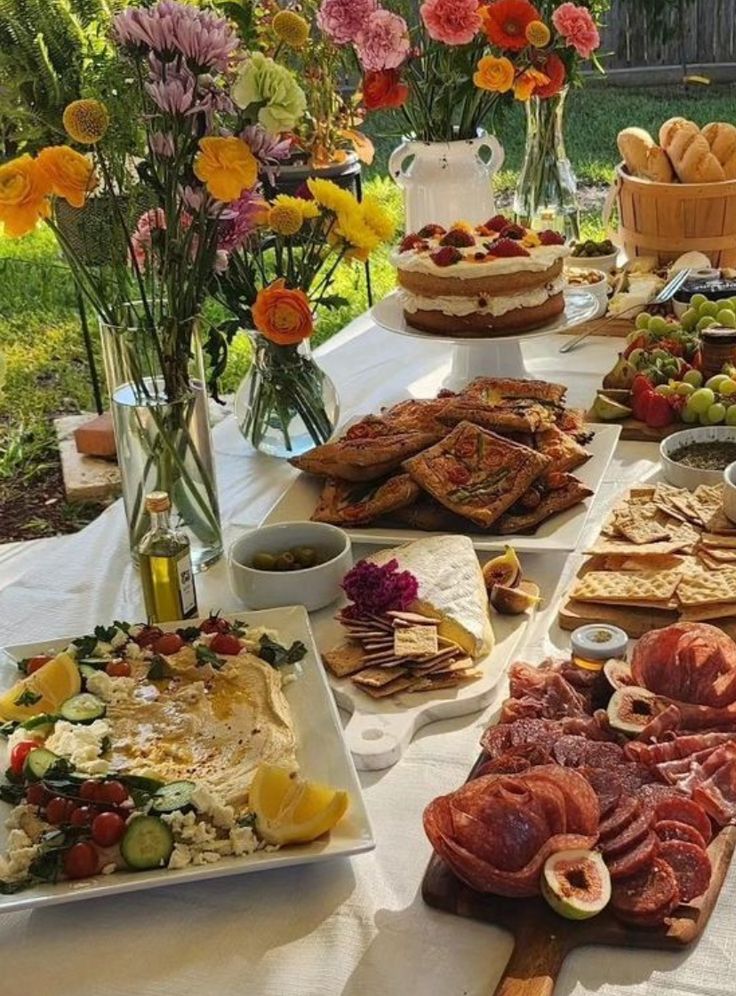 a table filled with lots of food on top of a white table cloth