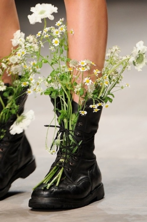 a pair of black boots with flowers in them