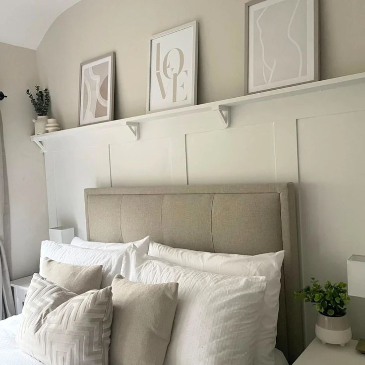 a bed with white sheets and pillows in a bedroom