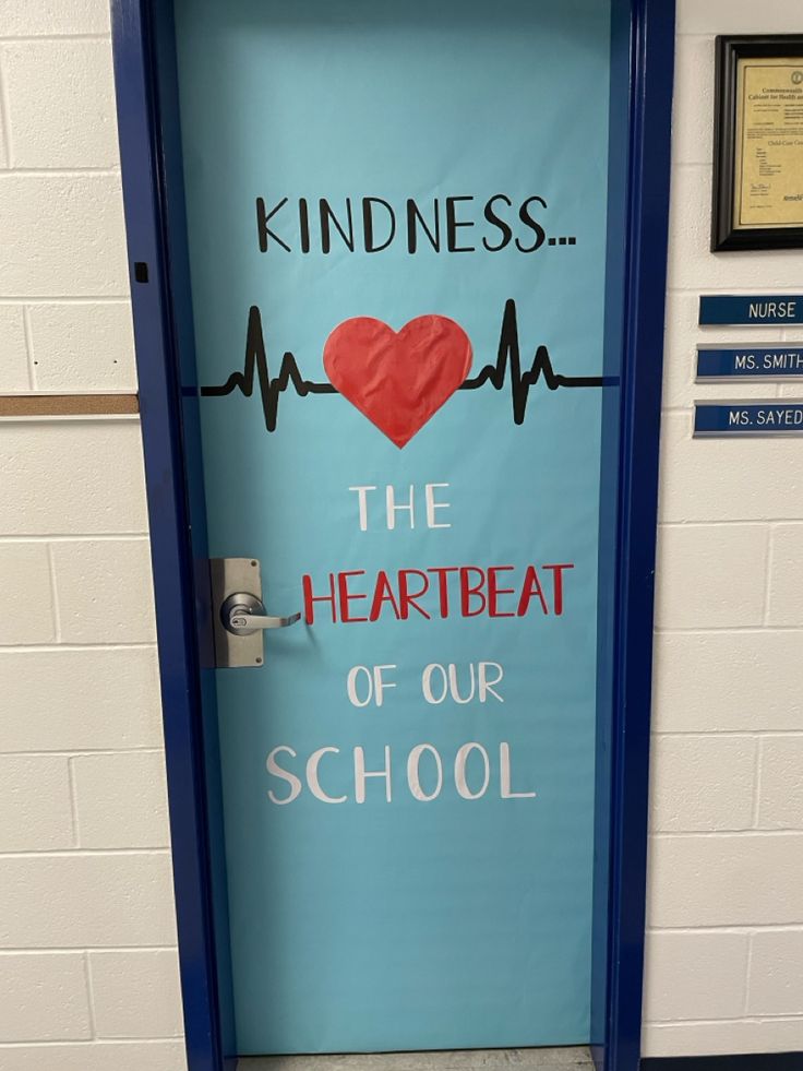 a blue door with a sign that says kindness the heartbeat of our school