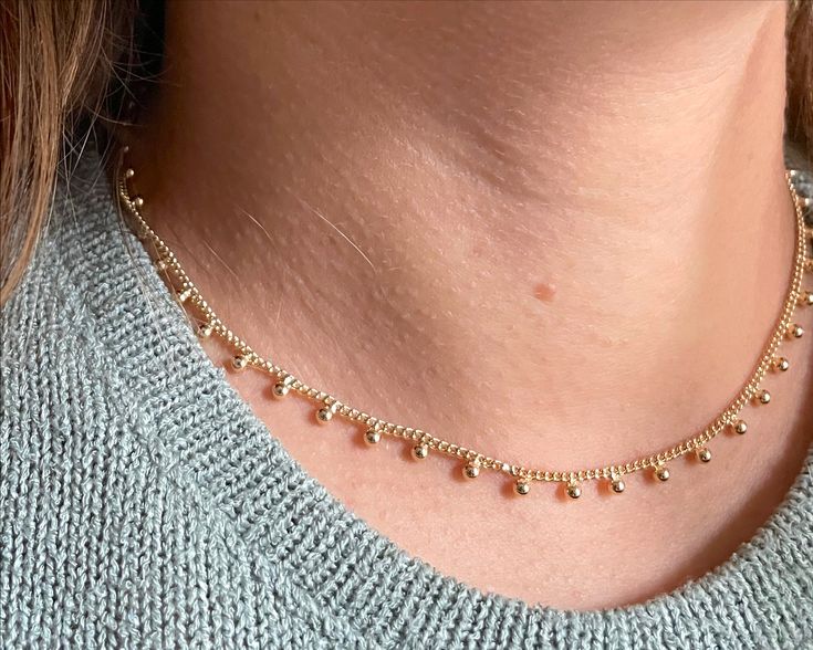 Enhance your sophisticated look with our Dots gold necklace. Crafted with gold fill for a luxurious touch, this adjustable necklace can be styled to your desired length. Elevate your style with this exclusive piece, perfect for adding an elegant touch to any outfit. Delicate 14k Gold Filled Lariat Jewelry, Dainty Jewelry With Adjustable Length, Elegant Adjustable Gold Charm Necklaces, 14k Gold Filled Tarnish Resistant Fine Necklace, Delicate 14k Gold Jewelry With Adjustable Chain, Elegant Gold Charm Necklace With Adjustable Length, Gold-tone Clavicle Chain Necklace For Gift, Gold Charm Necklaces With Adjustable Length, Gold Charm Necklace With Adjustable Length