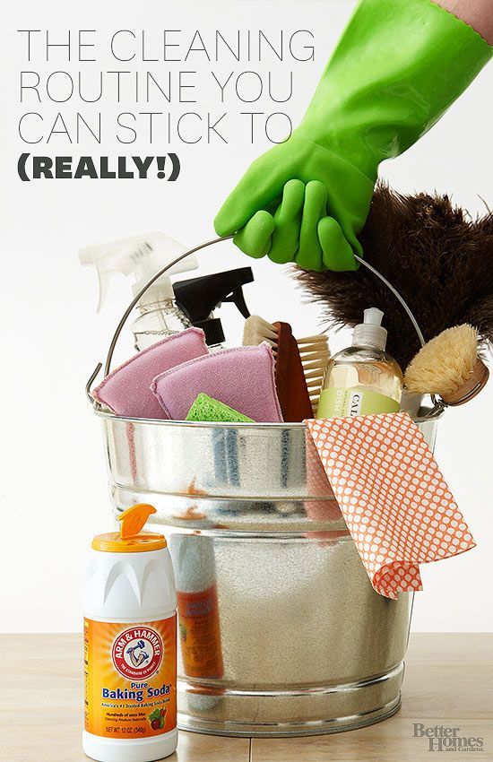 a metal bucket filled with cleaning products on top of a wooden table