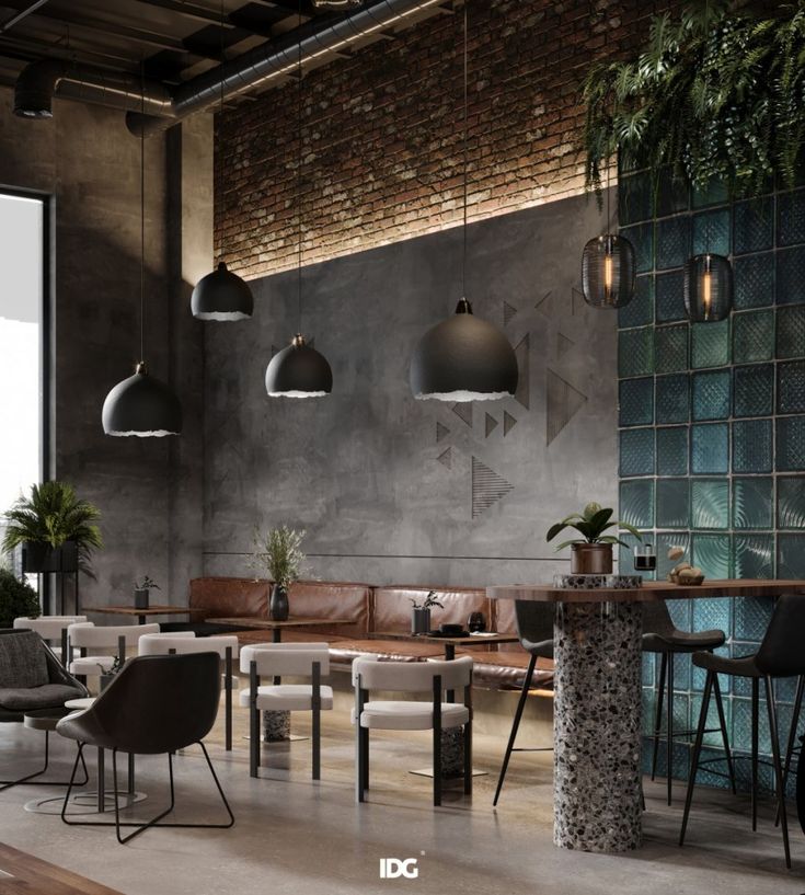 an industrial style living room with concrete walls and exposed ceiling lights, leather couches, potted plants, and modern lighting fixtures