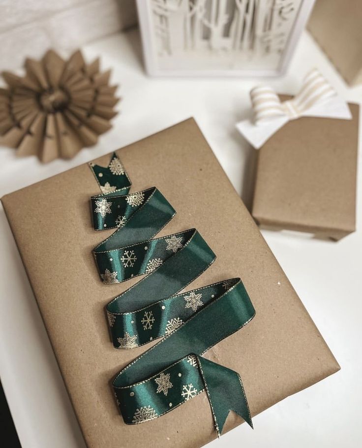 a brown box with green ribbon and snowflakes on it