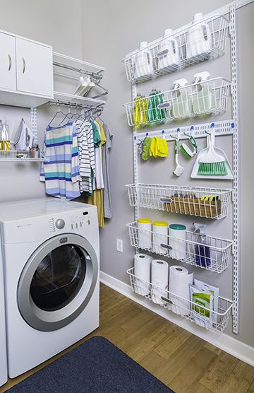 a washer and dryer in a laundry room with white shelving on the wall