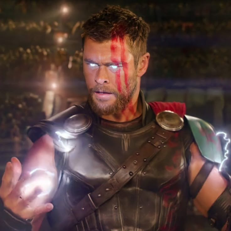 a man dressed as thor with blood on his face and chest, standing in front of an arena