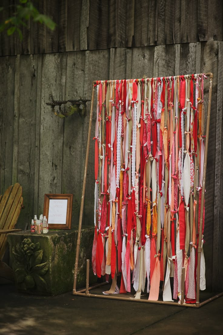 a display with ties hanging from it's sides in front of a wooden fence