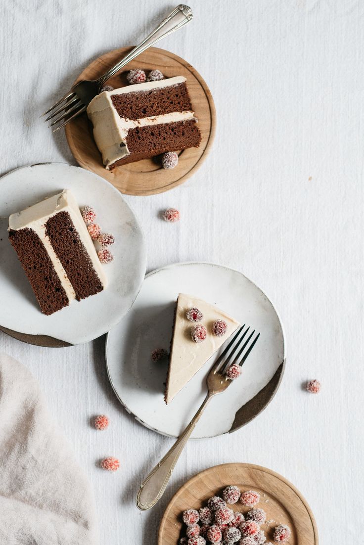 two slices of cake on plates with forks and spoons next to each other,