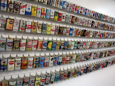 a wall mounted shelf filled with lots of different types of beer cans on it's sides