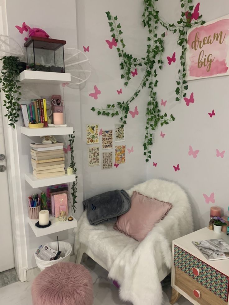 a white chair sitting in front of a book shelf filled with books and other items