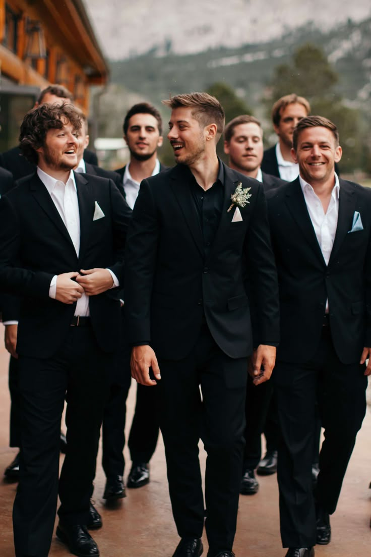 Our classic black suit is designed for the traditional bridal party. It is sure to set a bold back drop and make any accent colors pop. An absolute necessity, you will wear this again and again and again! Dark Moody Groomsmen, All Black Wedding Groomsmen, Black And White Wedding Groom Attire, Simple Groom Attire Black, Bridal Party Black Suits, Groom Attire Black Tie, Wedding Party Black Suits, Black Wedding Groomsmen Attire, Black On Black Wedding Suit