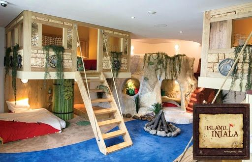 a room with bunk beds and ladders on the wall, in front of a blue carpeted floor