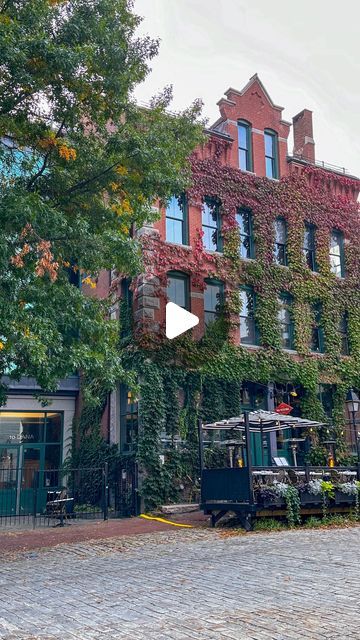 an old brick building with ivy growing all over it's sides and windows on the side