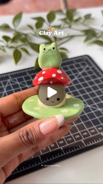 a person holding a tiny mushroom on top of a green plate