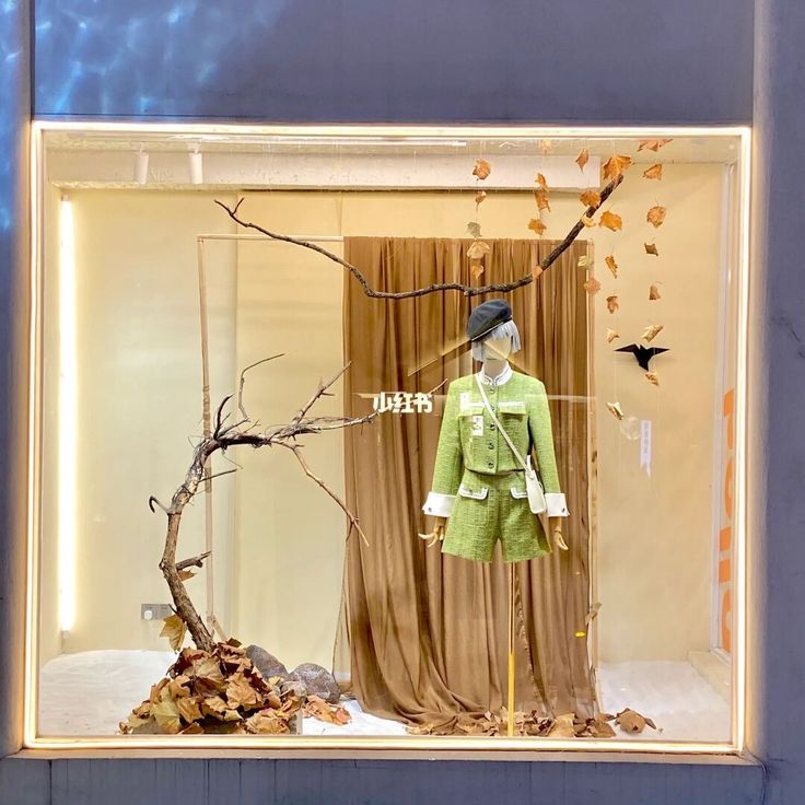 a display case with an image of a tree in the middle and leaves on the ground