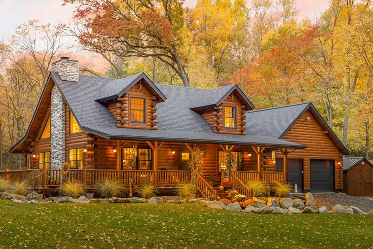 a log home in the woods surrounded by fall foliage