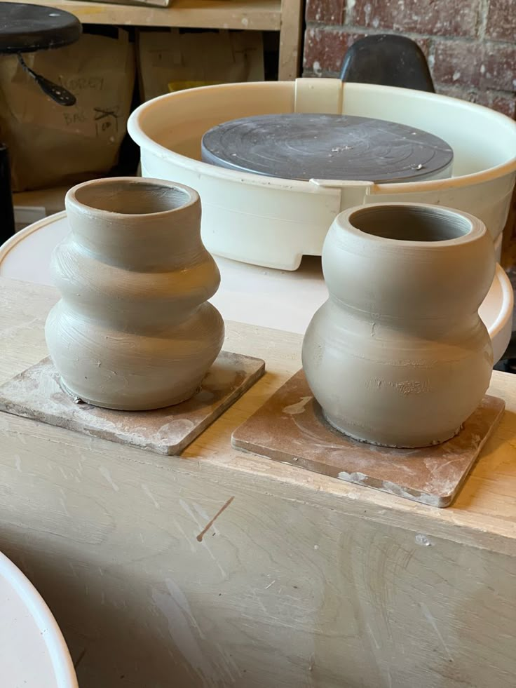 two clay pots sitting on top of a table