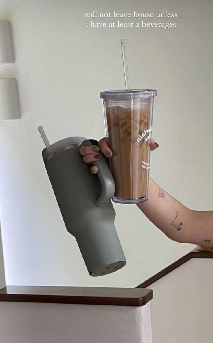 a person holding a cup with a straw in it and an instagram message on the screen