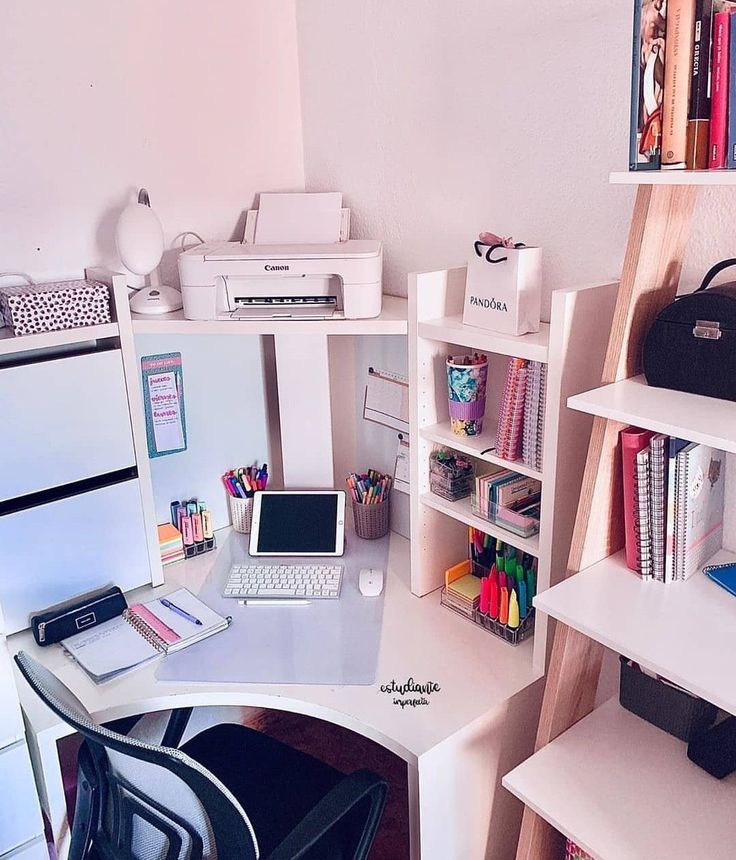 a white desk topped with a laptop computer next to a book shelf filled with books