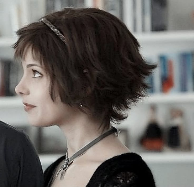 a man and woman standing next to each other in front of a bookshelf